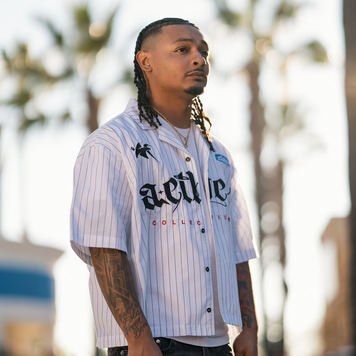 Man wearing a striped shirt with visible branding outdoors